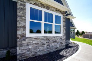 White vinyl double-hung windows on a suburban home with stone facade