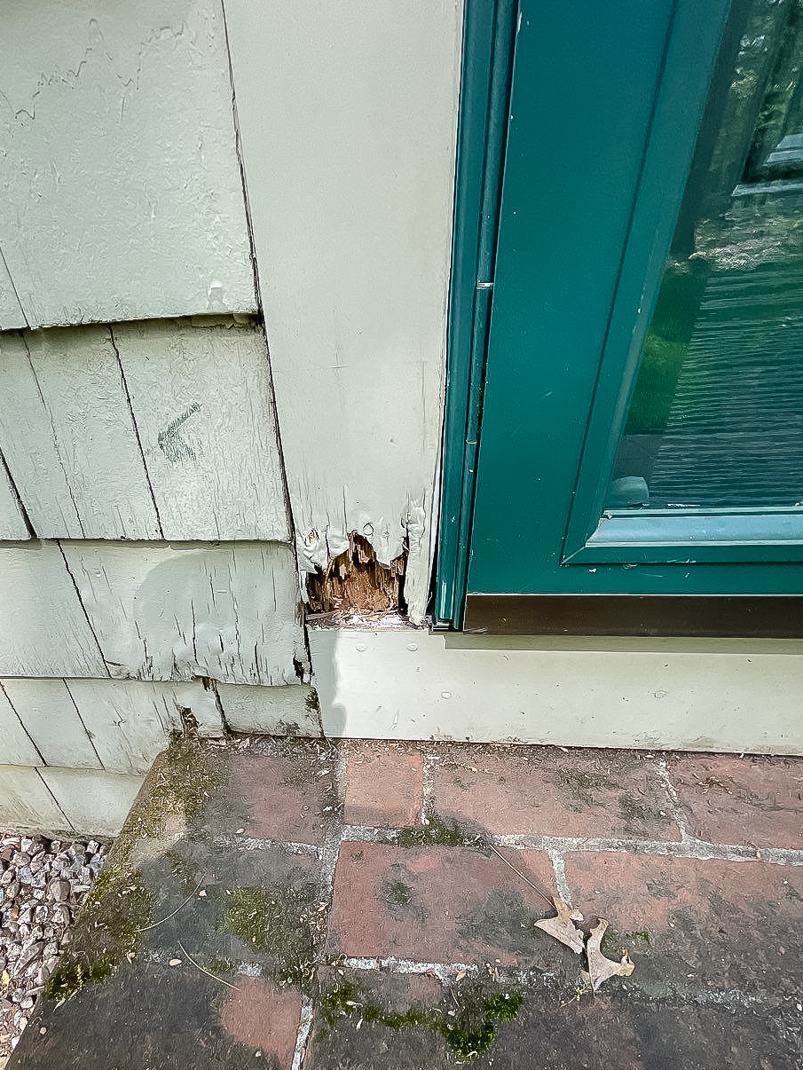 Closeup of corner of door where rot damage is evident