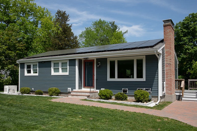 ranch style house with brand new siding in a grey-blue color; project completed by 12 Penny Exteriors